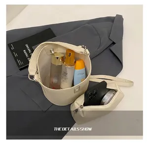 Interior view of beige bucket bag showing large capacity with matching small pouch