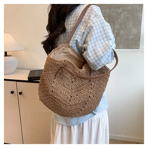 Detail of hand-woven straw tote with brown PU leather straps and spacious interior lining
