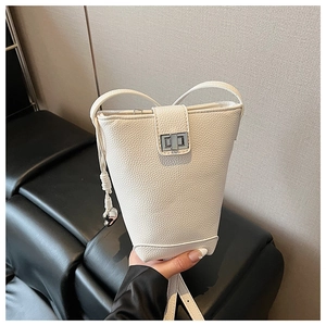 Detailed view of white lychee-pattern bucket bag featuring silver turn-lock and drawstrings