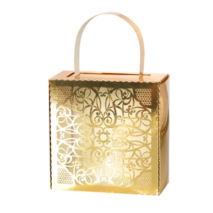 Macro detail of golden laser-cut lace candy box with elegant floral hollow pattern