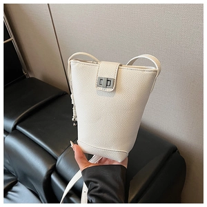 Detail view of white lychee grain leather bucket bag with silver metal swivel lock clasp
