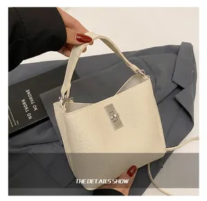 Close-up of white lychee leather handbag handle with silver D-ring and metal buckle