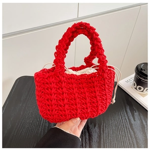 Macro detail of red hand-woven tote bag showing thick cotton texture and white drawstring liner