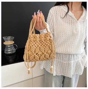 Macro detail of hand-woven beige bucket bag with tassel drawstrings and wooden beads