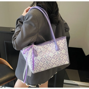 Close-up of tote bag featuring purple floral patterns and elegant lace ribbon decoration
