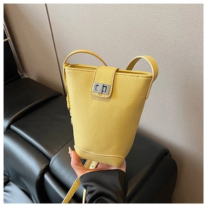 Detail showing bright yellow lychee leather bucket bag with silver metal swivel lock