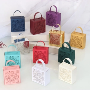 Macro shot of assorted laser-cut paper wedding favor boxes in elegant floral designs