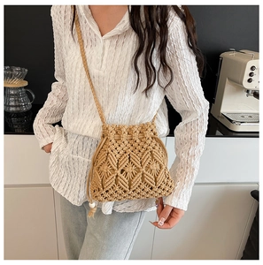 Detail of khaki macrame woven bucket bag with drawstring closure and bead tassels