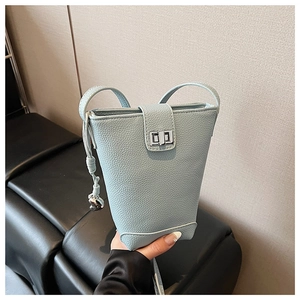 Macro shot of light blue lychee pattern leather bucket bag with silver twist lock