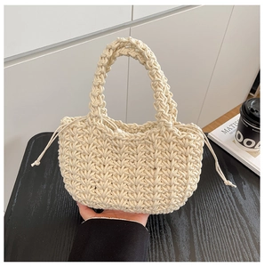 Detailed close-up of cream woven bucket bag featuring V-shaped texture and drawstring closure