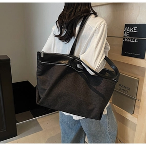 Detailed back view of a black large capacity tote bag with leather straps and silver zipper