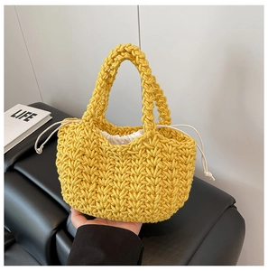 Detail of yellow hand-woven bucket bag with 3D texture and drawstring inner pouch