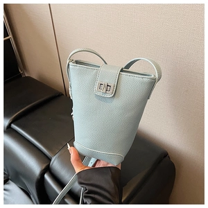Close-up of light blue bucket bag with lychee texture leather and silver twist lock