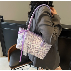 Detail of purple printed tote bag featuring white lace trim and elegant silk ribbon bows