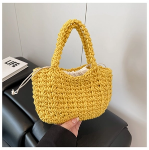 Detail of yellow hand-woven crochet bucket bag with a cream drawstring liner pouch