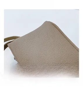 Close-up of beige lychee grain leather texture on casual crossbody bucket bag