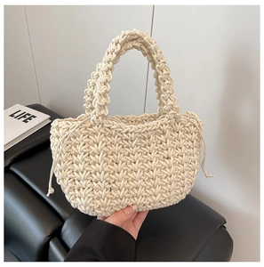 Detail of hand-woven cream bucket bag featuring textured cotton rope and drawstring