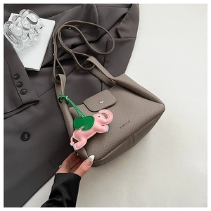 Detail view of grey lychee leather handbag featuring a pink elephant pendant and PANTOR logo