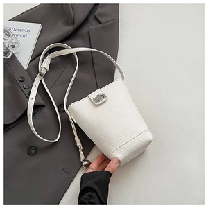 Close-up of cream white bucket bag with pebble leather texture and silver swivel lock