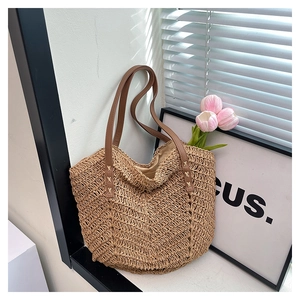 Detailed close-up of natural woven straw texture and premium brown leather shoulder strap