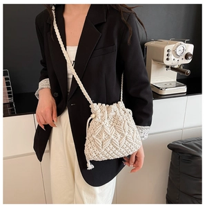 Close-up of the intricate diamond hollow knit texture on a cream woven bucket bag