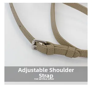 Detail of adjustable khaki faux leather shoulder strap with silver metal buckle and stitching