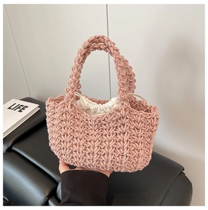 Detail shot of a pink woven bucket bag with handmade texture and white drawstring lining