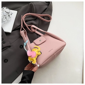 Pink lychee grain leather bucket bag featuring a vibrant elephant charm detail