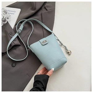 Detail of light blue lychee pattern bucket bag with silver twist lock and heart charm