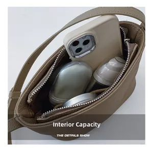 Close-up of brown pebbled leather bag interior showing large capacity for phone and cosmetics