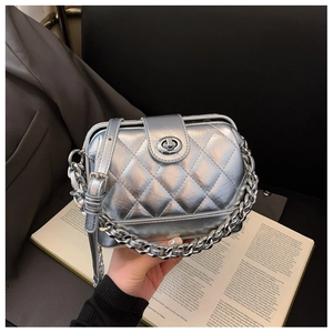 Macro detail of silver quilted metallic crossbody bag with chain and twist lock