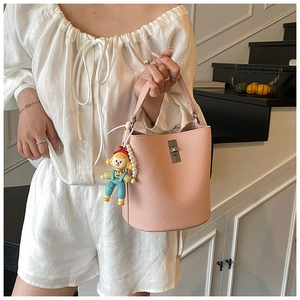 Detail of pink lychee leather bucket bag with silver twist lock and pearl charm