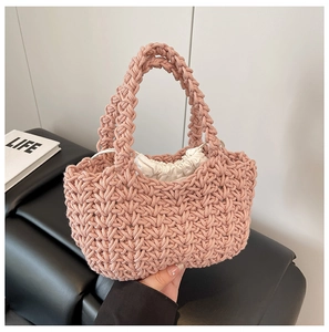 Detailed macro view of pink chunky knit woven handbag with a white drawstring inner pouch