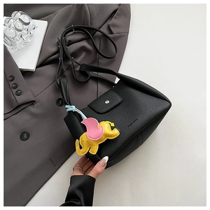 Litchi pattern black bucket bag on grey suit with yellow elephant charm detail