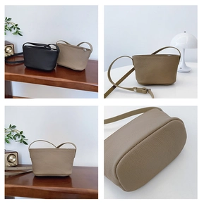 Detail view of lychee texture small bucket bags in black and khaki with silver zippers