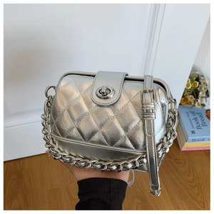 Detailed view of silver quilted crossbody bag with metallic latch and thick chain strap