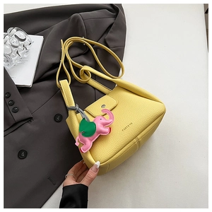 Macro shot of yellow pebble leather handbag with a pink elephant charm and Panto'in logo