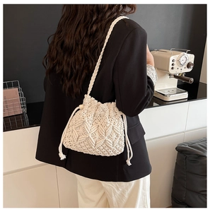 Detail of handmade macramé straw bucket bag with wooden beads and braided strap
