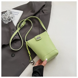 Detailed macro of light green pebbled leather bag with silver twist lock and heart charm