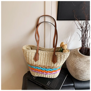 Detail of hand-woven straw tote bag with colorful stripes and brown leather straps