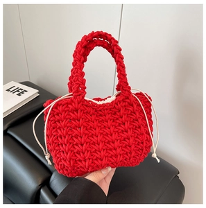 Detail of red hand-woven bucket bag with a white drawstring inner liner and thick handle