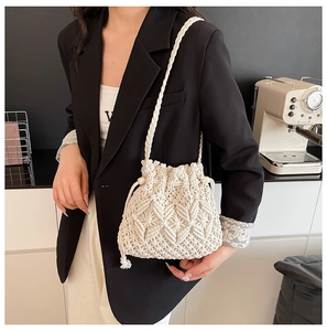 Detail of white woven cotton rope bucket bag with textured diamond pattern and drawstring
