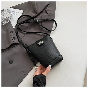 Detail of black lychee grain leather crossbody bag with silver metal swivel lock