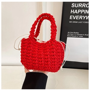 Detail of red hand-woven bucket bag with white drawstring liner and knit texture