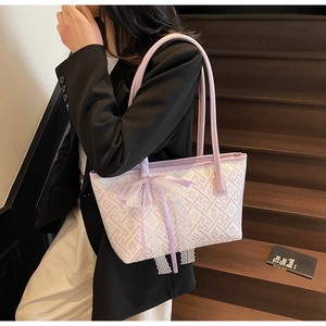 Detail of lavender tote bag featuring white geometric patterns and a lace bow decoration