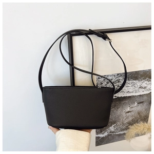 Close-up of black litchi pattern leather texture and metal zipper on the shoulder bag
