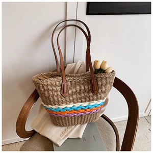 Detailed texture of hand-woven straw bucket bag with colorful stripes and leather straps
