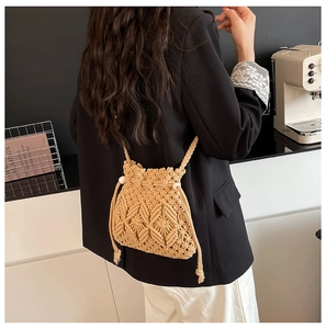Close-up of geometric crochet pattern and drawstring on beige woven straw bucket bag