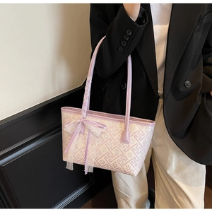 Detail of lavender tote bag featuring geometric patterns and a lace silk bow decoration