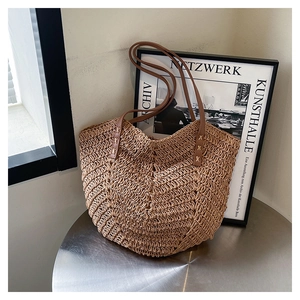 Close-up of V-shaped woven texture on a large capacity straw tote bag with leather straps